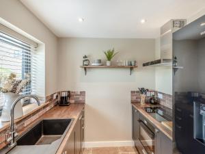 a kitchen with a sink and a window at The Old Stables 1 - Uk46682 in Shipton under Wychwood +6 photos