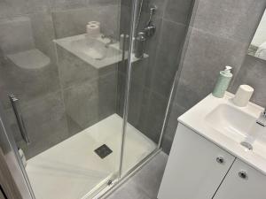 a shower with a glass door next to a sink at La Pescheria - Mini Apartments in Catania