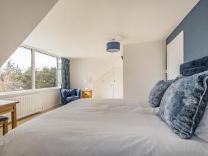 a bedroom with a large bed with blue pillows at Brooksyde,Kippford in Kippford