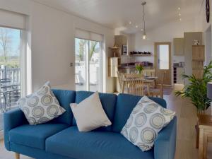 a blue couch with pillows in a living room at Cree Lodge - Uk13636 in Creetown