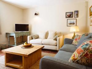 a living room with a couch and a table at New Lane Cottage in Worstead