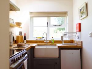 a kitchen with a sink and a window at New Lane Cottage in Worstead