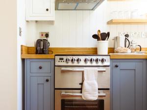 a kitchen with a stove with a towel on the oven at New Lane Cottage in Worstead +15 photos