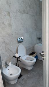 a bathroom with a white toilet and a sink at Casa Focșani in Cîmpineanca