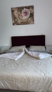a bed with a white comforter and two pillows at Casa Focșani in Cîmpineanca