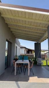 a patio with a table and chairs under awning at Casa Focșani in Cîmpineanca