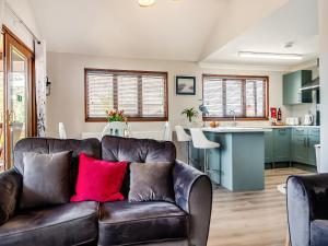 a living room with a brown couch and a kitchen at River Rest-B6863 in Brundall