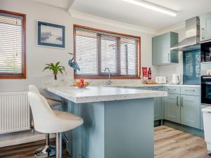 a kitchen with blue cabinets and a white counter top at River Rest-B6863 in Brundall