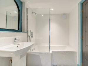 a white bathroom with a sink and a shower at Frenchgate Mews in Richmond