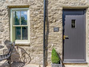 a stone house with a purple door and a bench at Frenchgate Mews in Richmond