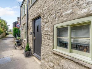a stone building with a black door and a window at Frenchgate Mews in Richmond