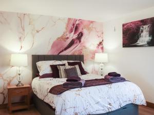 a bedroom with a large bed with two lamps at Ty'n Rallt in Bodorgan +14 photos