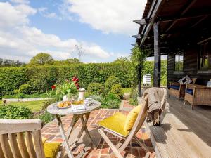 a dog standing on a patio with a table at Brook Farm Annex in Tenterden