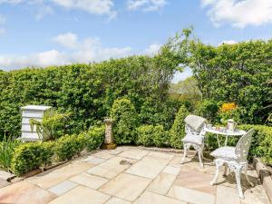 a patio with two chairs and a table at Brook Farm Annex in Tenterden +14 photos