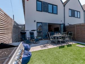 a patio with a table and chairs in a backyard at Nursery Mews in Whitstable