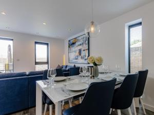 a dining room with a table and a blue couch at Nursery Mews in Whitstable +16 photos