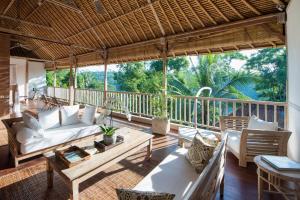 porche con sofá y sillas en la cubierta en Villa Shamballa, en Ubud