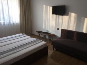 a hotel room with a bed and a couch at Paradox in Eforie Sud