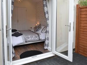 a bedroom with a bed through a sliding glass door at Oswald Lodge in Llanon +6 photos