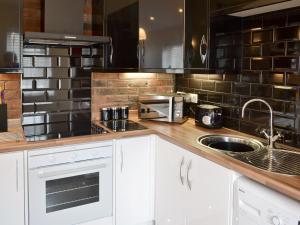 a kitchen with a counter with a sink and a microwave at Oswald Lodge in Llanon