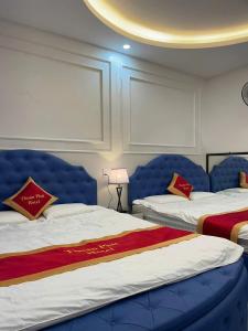 a hotel room with two beds with blue headboards at Nhà Nghỉ Thuận Phát in Làng Chang +57 photos