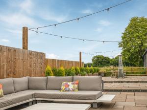 a couch on a patio with a fence at Dodds Barn in Fersfield