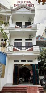 a white building with a motorcycle parked in front of it at Nhà Nghỉ Thuận Phát in Làng Chang