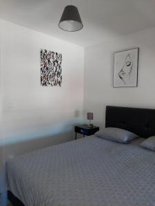 a bedroom with a bed and two pictures on the wall at Appartement meublé Tilff in Esneux