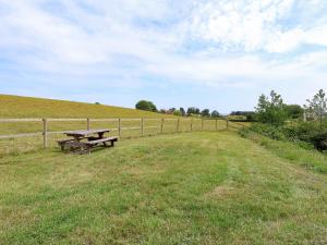 a picnic table in a field next to a fence at Plough Share in Gloucester