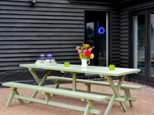 a picnic table with a vase of flowers on it at Burfields Barn in Botesdale