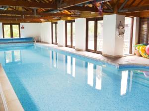 a large swimming pool with clear blue water at Burfields Barn in Botesdale +21 photos