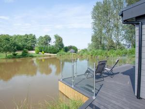 two chairs sitting on a deck next to a river at Kingfisher Lodge - Uk33889 in Cullompton