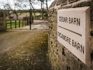 a sign on a wall with a gate barn and a fence at Sycamore Barn - Uk33353 in Buttershaw
