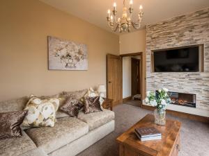 a living room with a couch and a fireplace at Sycamore Barn - Uk33353 in Buttershaw