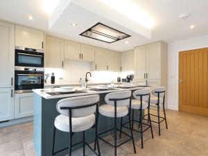 a kitchen with a large island with bar stools at Chancery View in Ross on Wye