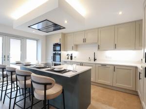 a kitchen with a large island with bar stools at Chancery View in Ross on Wye +32 photos
