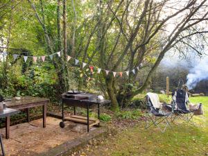 a picnic area with a grill and a picnic table and a tree at Uk45543-The Threshing Barn in Sticklepath