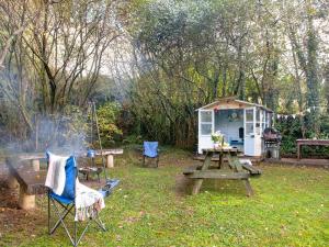 a picnic table and a grill and a house at Uk45543-The Threshing Barn in Sticklepath