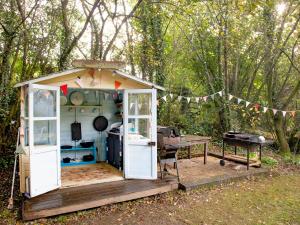 a small shed with a table and a grill at Uk45543-The Threshing Barn in Sticklepath