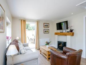 a living room with a couch and a fireplace at Wits End Cottage in Martin
