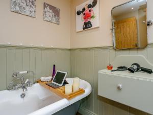 a bathroom with a sink and a laptop on a counter at Wits End Cottage in Martin +16 photos
