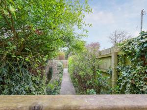 a garden path with trees and a fence at Brook House - Uk43013 in Berkeley