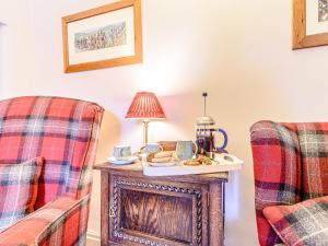 a living room with two chairs and a table with a plate of food at Ghyll View in Gunnerside