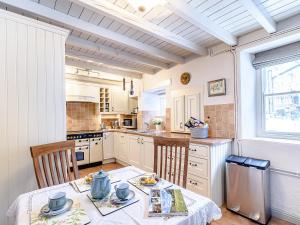 a kitchen with a table and chairs and a window at Ghyll View in Gunnerside +15 photos