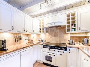 a kitchen with white cabinets and a stove top oven at Ghyll View in Gunnerside