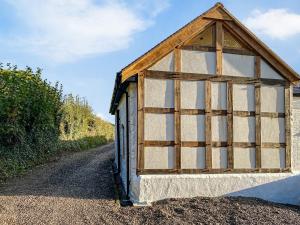 a small building with a window on a dirt road at Quabbs Head Cottage in Mathon +26 photos