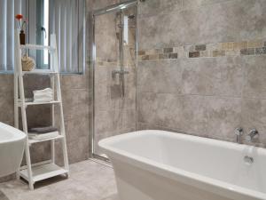 a bathroom with a bath tub and a shower at Henry-Oscar House in Winchelsea