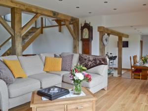 a living room with a couch and a table with flowers at Henry-Oscar House in Winchelsea
