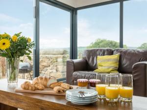 a table with a tray of bread and orange juice at Moorgate Cottage - Ukc3380 in Kelbrook