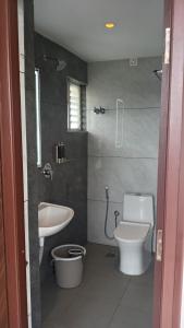 a bathroom with a sink and a toilet and a shower at Hotel Amulya Royal Inn in Bangalore +48 photos